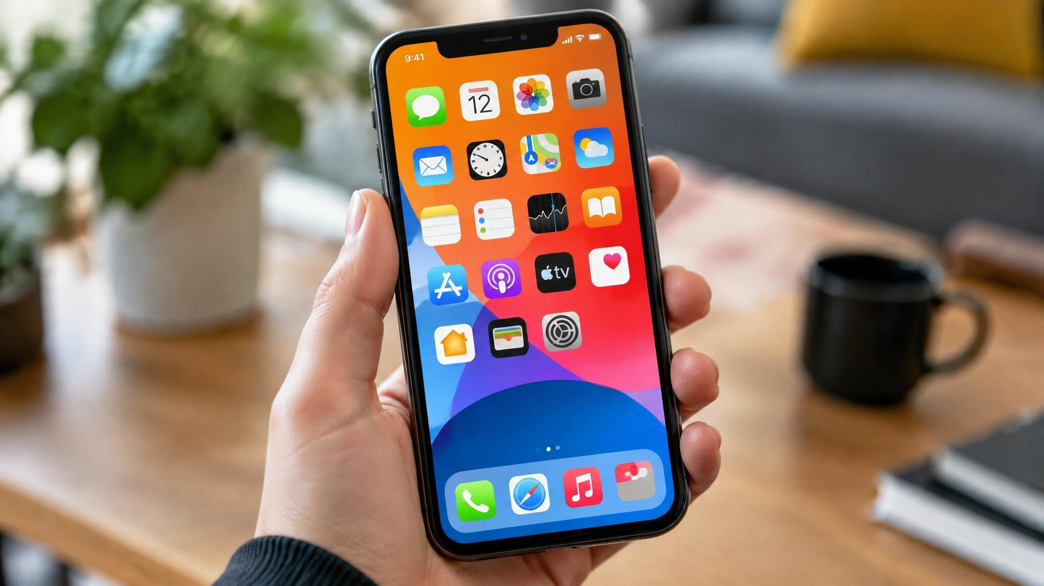 Hand holding a smartphone showing app icons